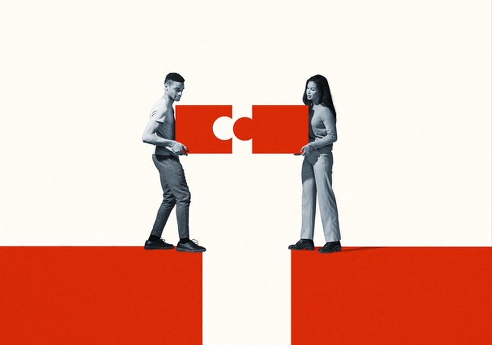 Young man and woman positioning orange puzzle pieces while standing at the edge of cliff against white background (Foto: Getty Images) — Foto: Glamour