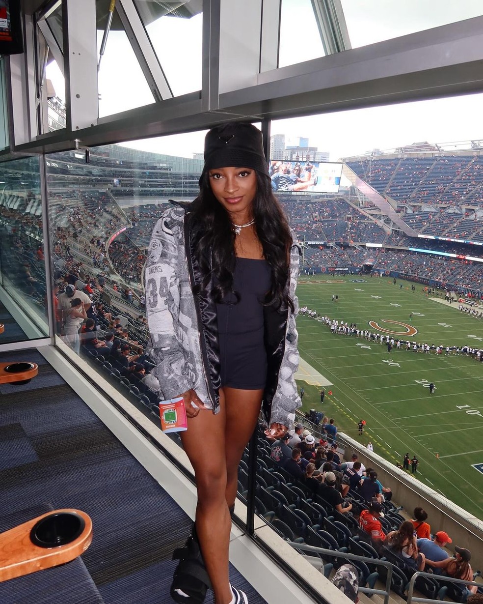 Simone Biles usa look composto por vestido curto preto combinado com jaqueta oversized — Foto: @simonebiles