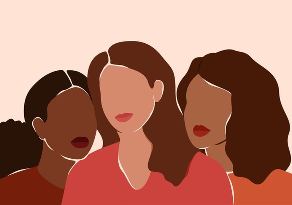 Three beautiful women with different skin colors together. African, latin and caucasian girls stand side by side. Sisterhood and females friendship.  Vector illustration for International Women's day (Foto: Getty Images/iStockphoto) — Foto: Glamour