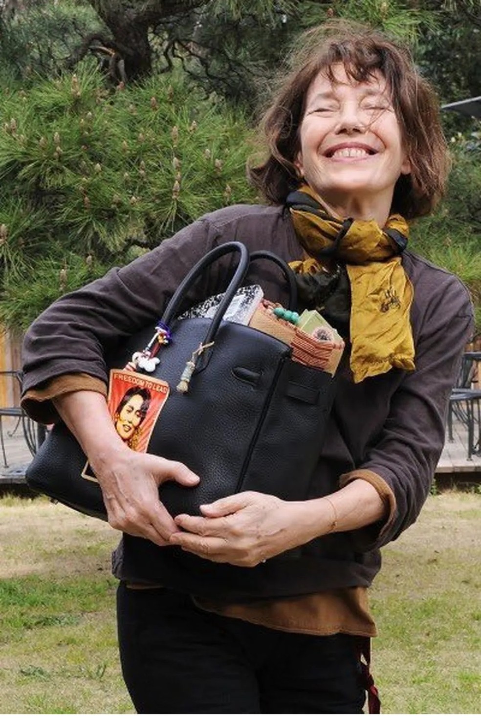 Jane Birkin com a bolsa que leva o seu nome repleta de acessórios — Foto: Reprodução