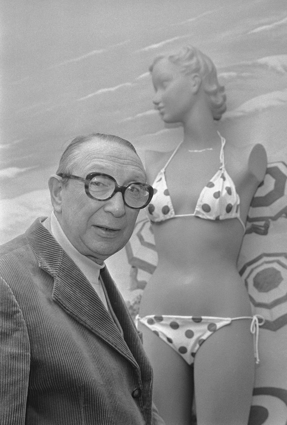 Louis Réard  ao lado do primeiro biquíni — Foto: glamour