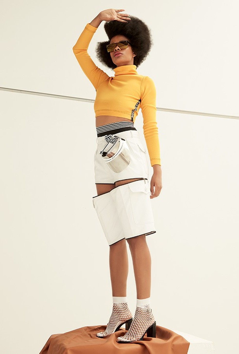 Top, R$ 495, À La Garçonne; hot pant, R$ 40, Renner; calça usada como bermuda, R$ 4.980, Reinaldo Lourenço. Óculos, R$ 85, Damn Project; viseira, Dior; meias, R$ 20, Forever 21; sandálias, R$ 190, Santa Lolla  — Foto: Glamour