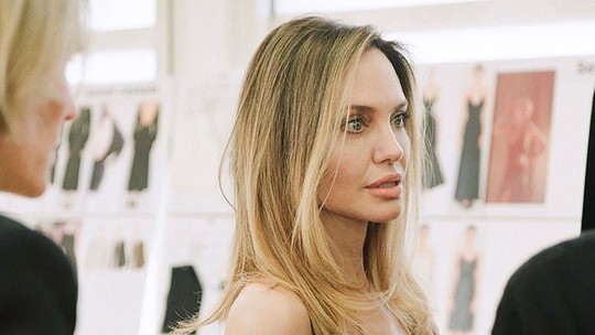 Angelina Jolie surpreende e surge loiríssima em bastidores do lançamento da marca própria