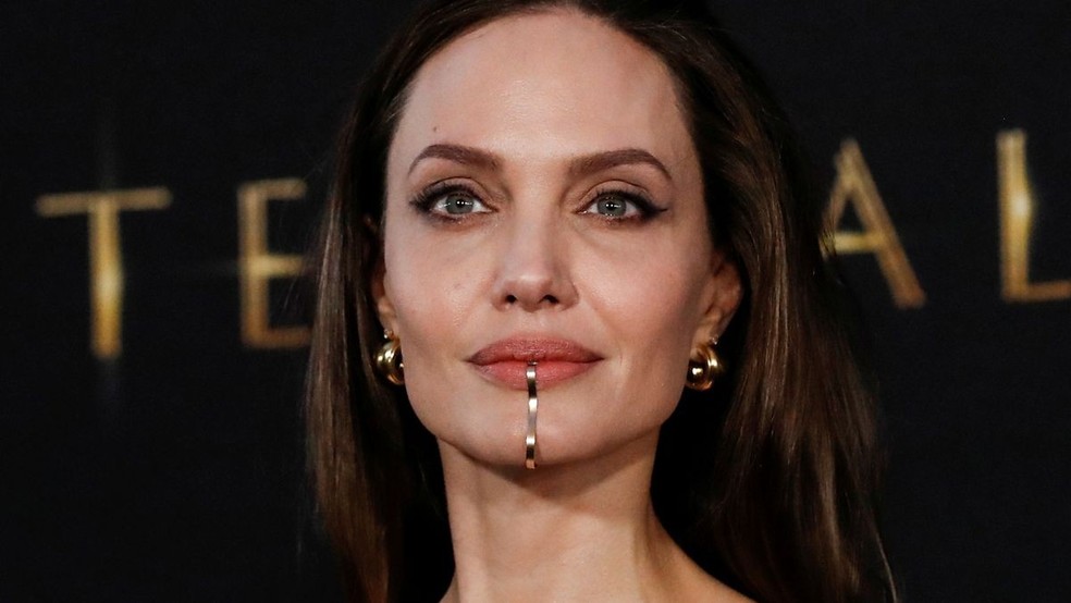 Angelina Jolie exibindo um 'chin cuff' na premiere de seu novo filme, The Eternals (Foto: Reprodução/Reuters ) — Foto: Glamour