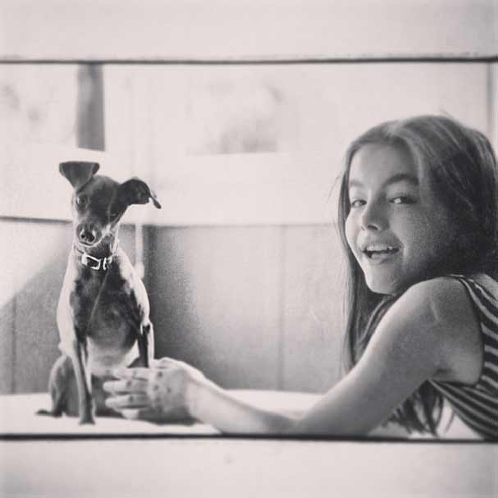 Camilla Belle na infância, ao lado do primeiro cãozinho (Foto: Reprodução/Instagram) — Foto: Glamour