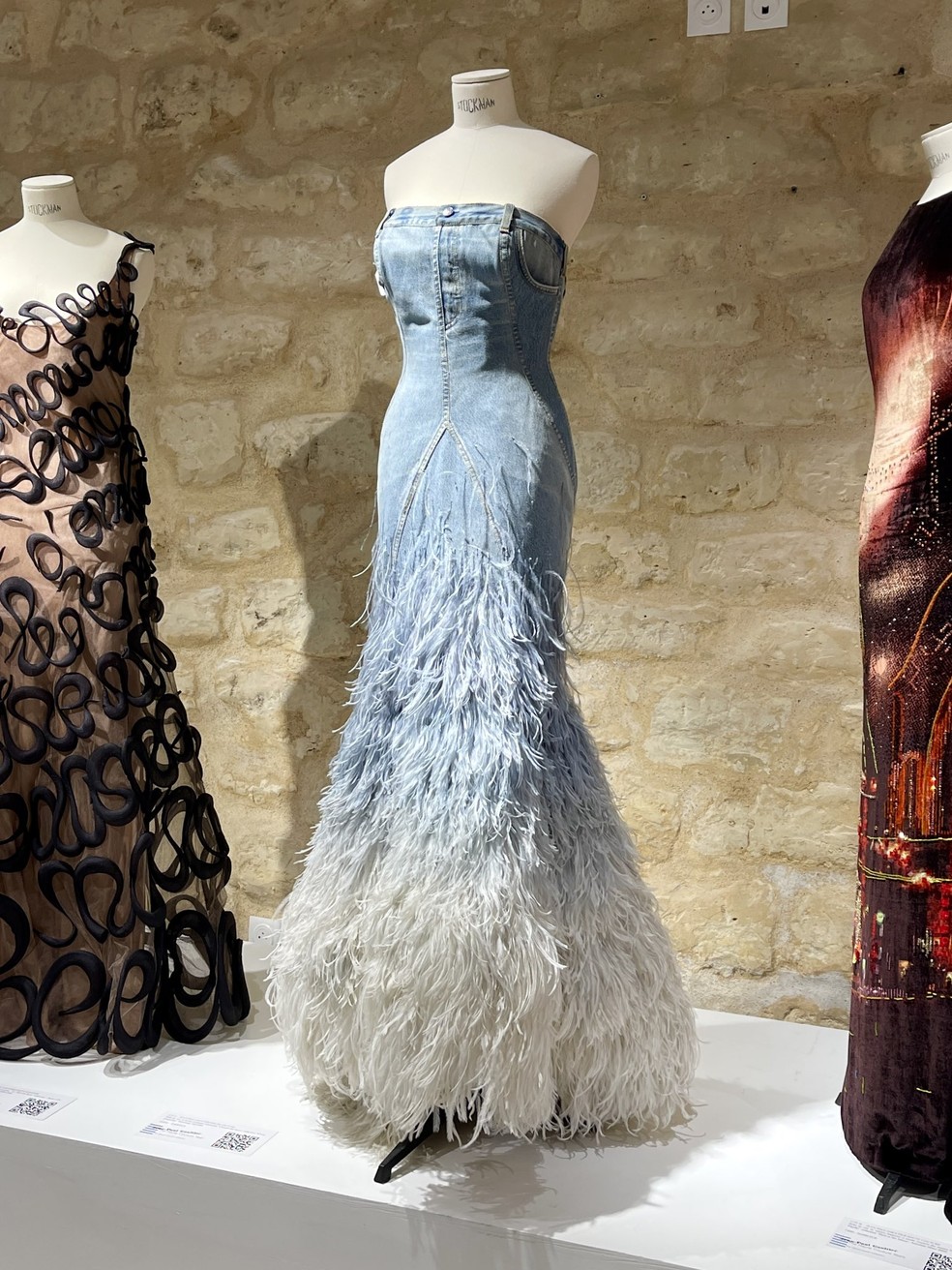 Vestido jeans com barra degradê de penas de avestruz de Jean Paul Gaultier — Foto: Reprodução