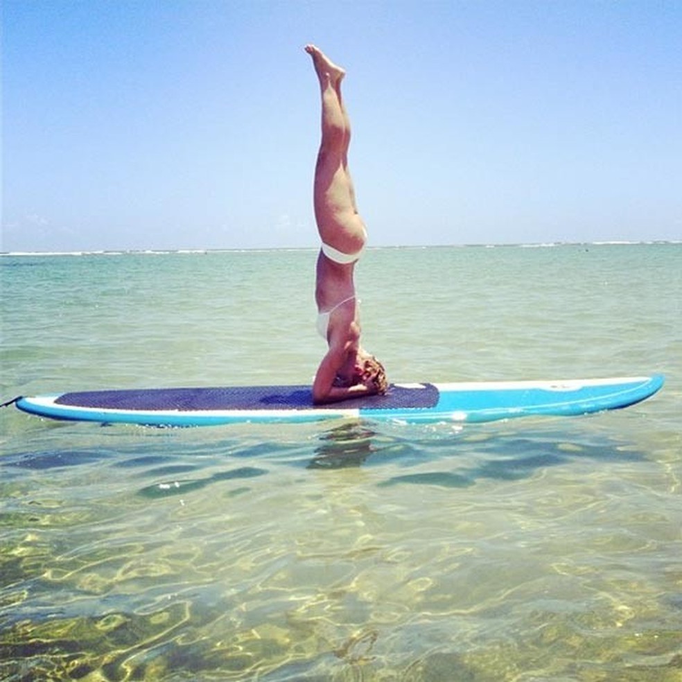 Carolina Dieckmann se equilibra em cima da prancha... De cabeça para baixo! (Foto: Reprodução/Instagram) — Foto: Glamour