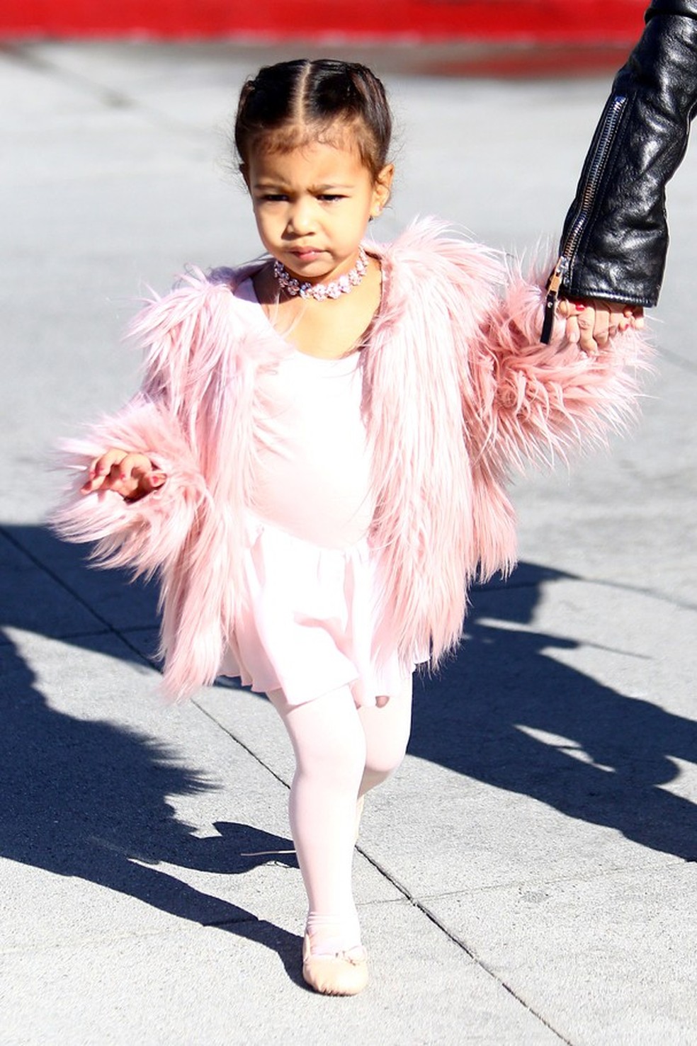 A pequena Nori a caminho da aula de ballet de casaco rosa, muito fofa! (Foto: AKM ) — Foto: Glamour
