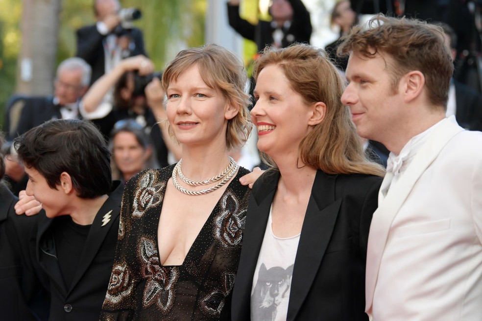 Justine, ao centro, entre Sandra Hüller, e Antoine Reinartz  — Foto: Getty Images