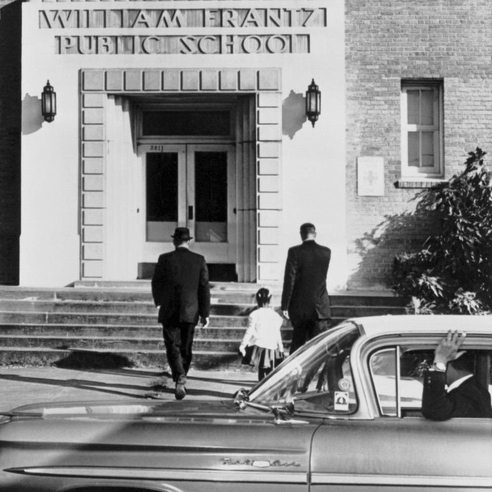 Momento em que a pequena Ruby Bridges, com apenas 6 anos, sobe as escadas da escola onde cursaria o primeiro ano do Fundamental, em New Orleans, Louisiana. A data era 28 de novembro de 1960 (Foto: Getty Images) — Foto: Glamour