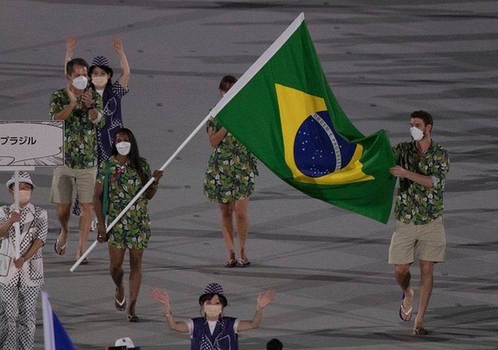 Bruninho, do vôlei, e Ketleyn Quadros, do judô, representando a delegação brasileira na abertura das Olimpíadas de Tóquio (Foto: @timebrasil) — Foto: Glamour